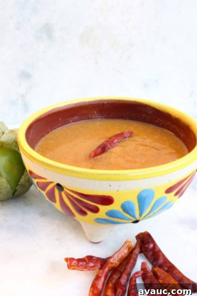 Roasted Tomatillo Salsa with a Chile de arbol and surrounded by more chiles and tomatillos