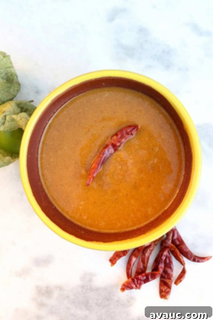 Roasted Tomatillo Salsa with a Chile de arbol and surrounded by more chiles and tomatillos
