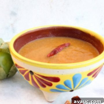 Roasted Tomatillo Salsa with a Chile de arbol and surrounded by more chiles and tomatillos
