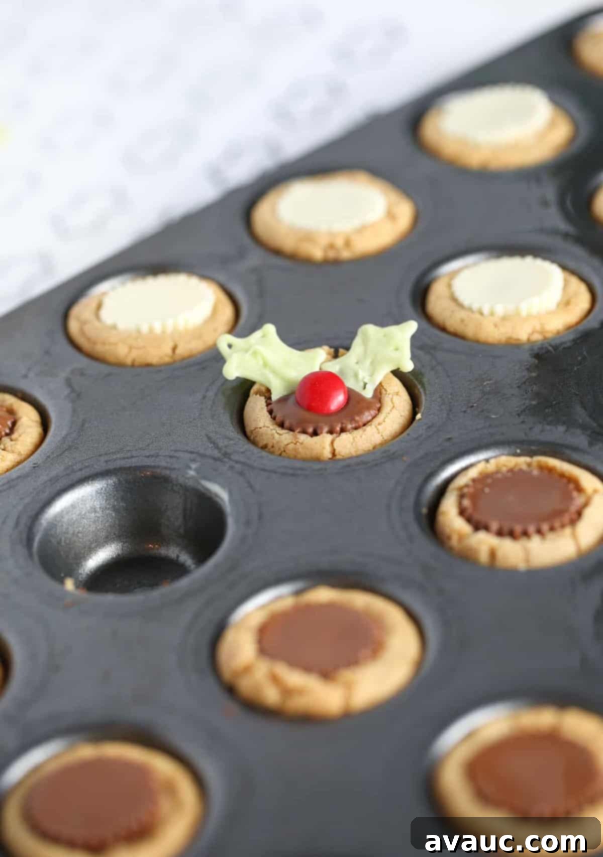 Holly Jolly Cookie Cups 10 Mini muffin tin with peanut butter cookie cups to make easy Christmas holly cookie cups.