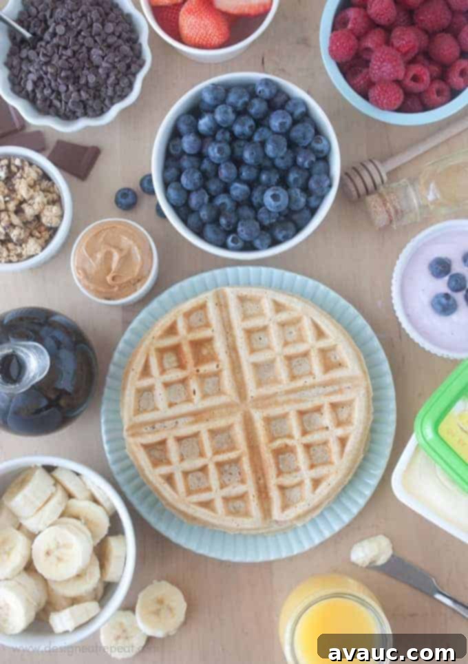 Overhead picture of waffle bar with waffle toppings. Blueberries, raspberries, peanut butter, bananas, and more.
