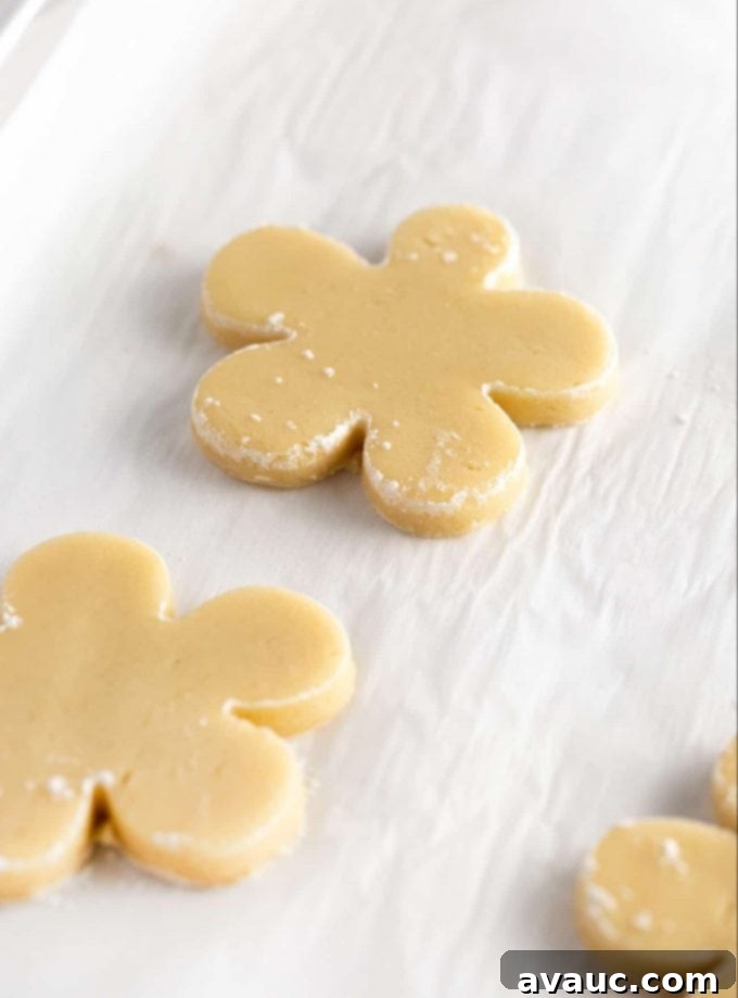 Flower shaped sugar cookie dough on baking sheet