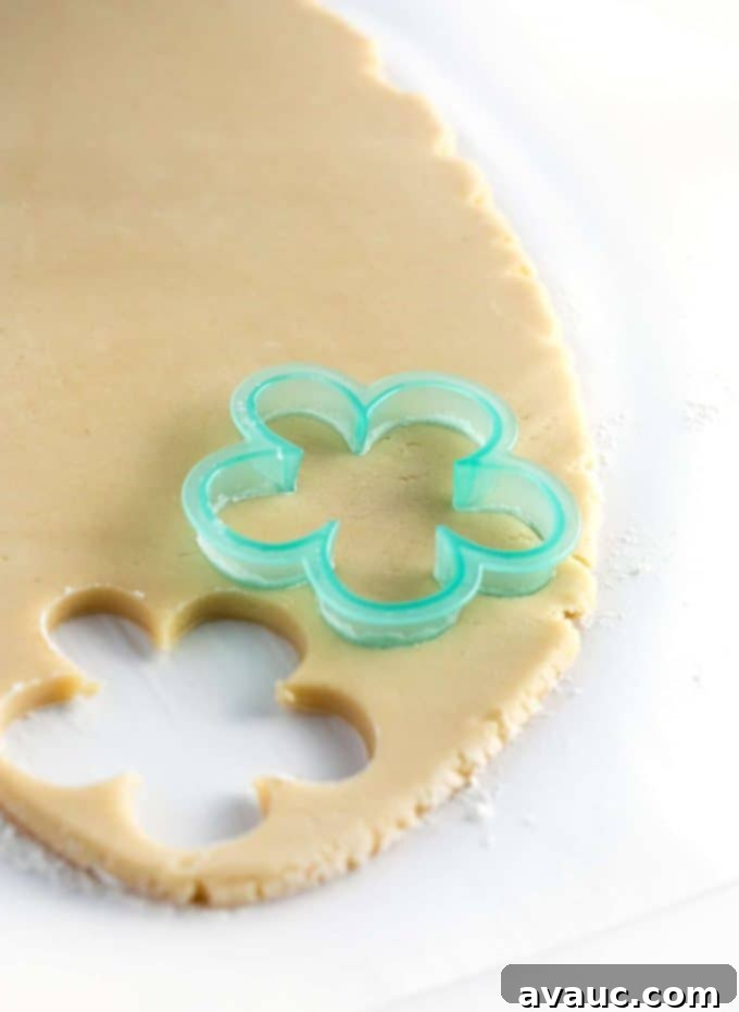 Mastering Flawless Cut Out Sugar Cookies 14 Flower cookie cutter actively cutting out a sugar cookie shape from rolled dough