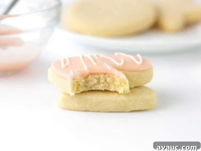 A sugar cookie with a bite taken out, showing the perfect consistency and smooth finish of the powdered sugar icing.