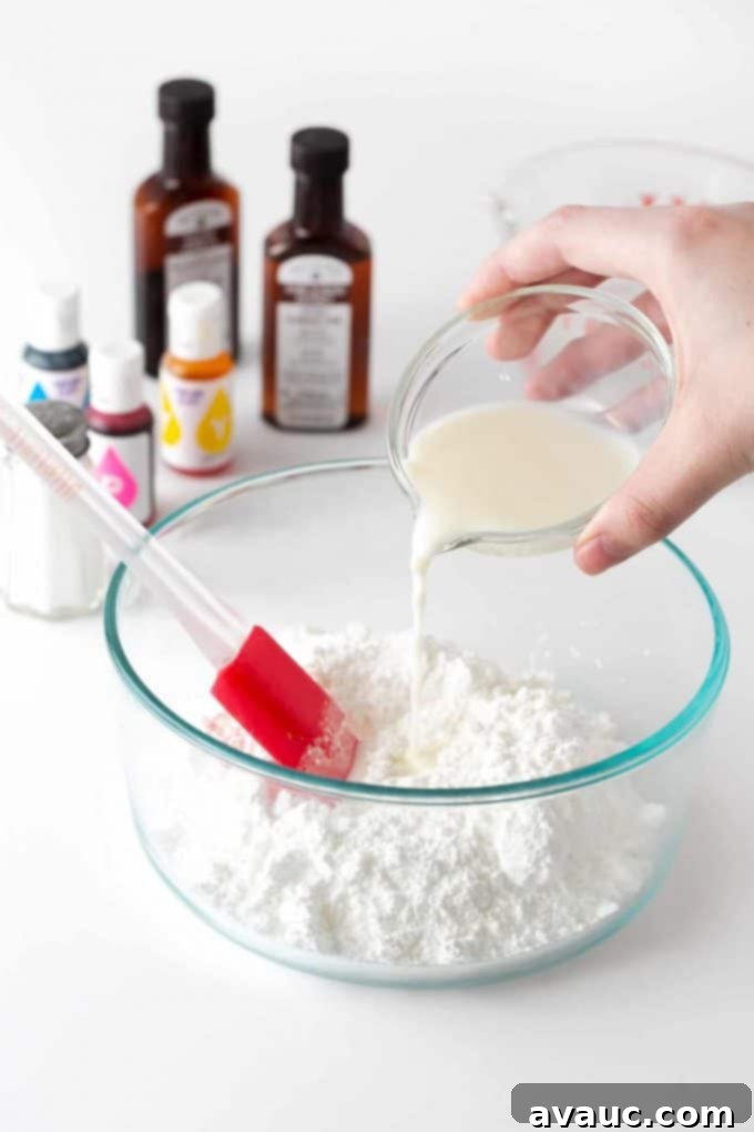 A hand pouring milk into a bowl containing powdered sugar, demonstrating the first step in making cookie icing.