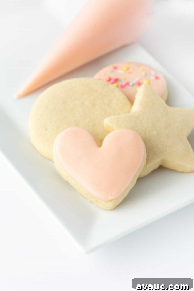 A collection of vibrant pink iced sugar cookies neatly arranged on a cooling rack, showcasing the smooth, soft-set powdered sugar icing.
