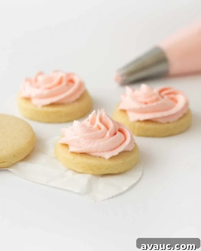 Pink sugar cookie buttercream on cookie, showcasing its fluffy texture