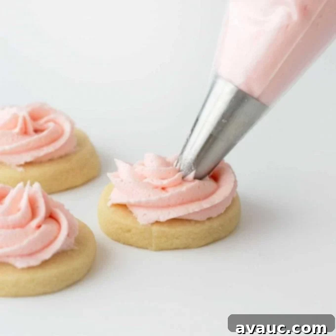 Sugar cookie buttercream being piped onto a cookie in a swirl pattern