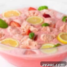 Blushing Strawberry Sherbet Punch 11 Pink Strawberry Sherbet Punch garnished with fresh fruit in a punch bowl.