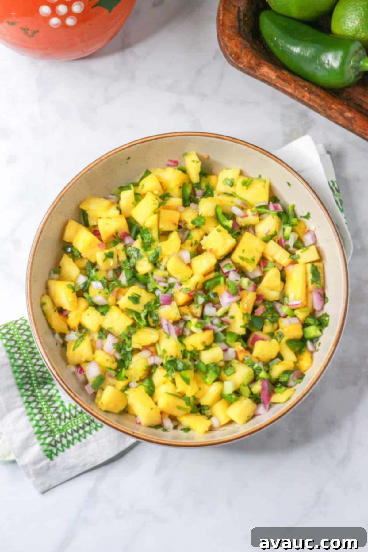 Sweet Heat Pineapple Jalapeño Salsa 10 Above shot of pineapple jalapeño salsa in a bowl with some ingredients behind it