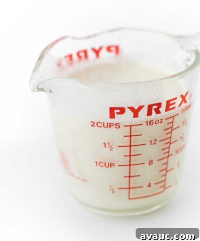 Close-up of heavy whipping cream being whipped to stiff peaks in a mixing bowl with an electric mixer