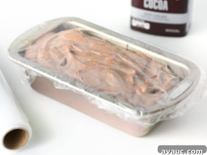 Chocolate no-churn ice cream mixture poured into a metal loaf pan, ready for freezing
