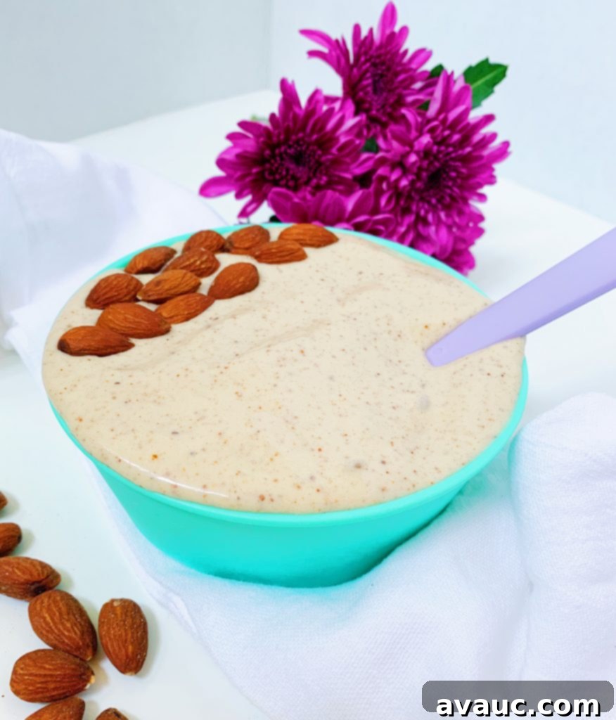 Creamy No-Churn Banana-Almond Butter Ice Cream in a bowl, garnished with sliced almonds.