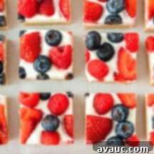 Sugar Cookie Fruit Pizza Bars 13 Close-up of a square slice of sugar cookie fruit pizza with mixed berries and cream cheese frosting.
