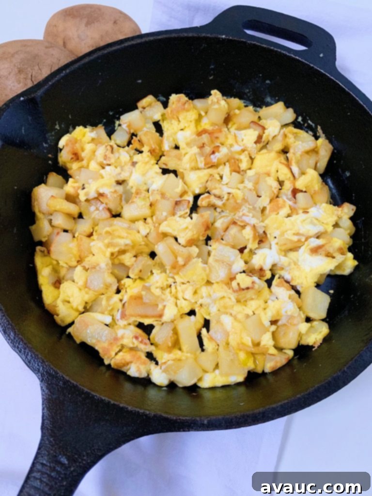 Hearty Potato and Egg Scramble 7 A hearty plate of Papas con Huevo (Potato and Egg Scramble), ready for a satisfying Mexican breakfast, garnished with fresh herbs.