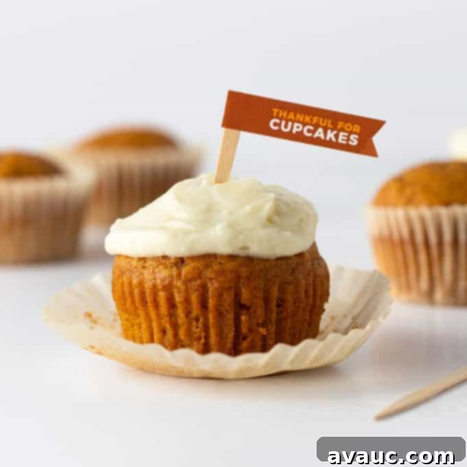 Close-up of a frosted pumpkin cupcake, showing its moist texture and creamy topping.