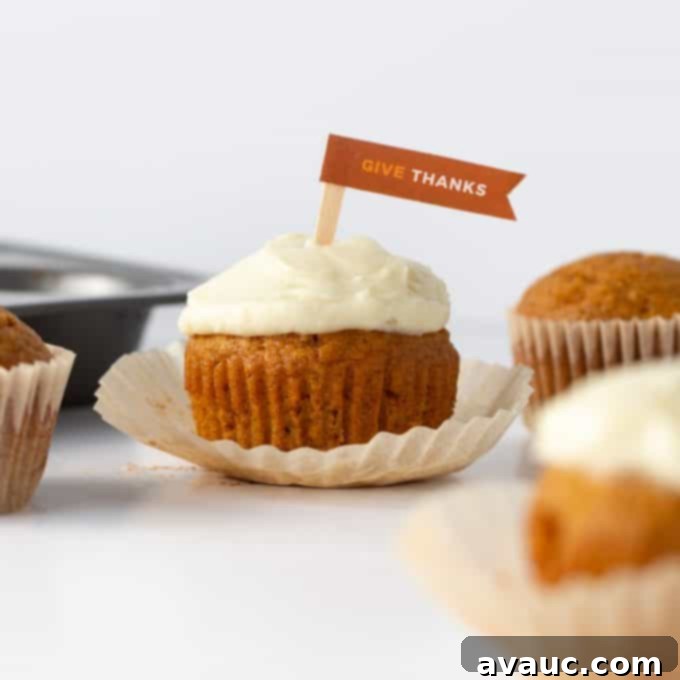 Finished pumpkin cupcakes, decorated with Fall sprinkles and a small pumpkin topper.