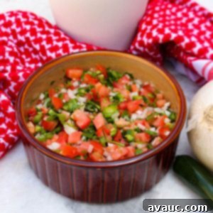 Vibrant Fresh Pico de Gallo 10 Bowl of salsa bandera with a plant and red cloth in the background