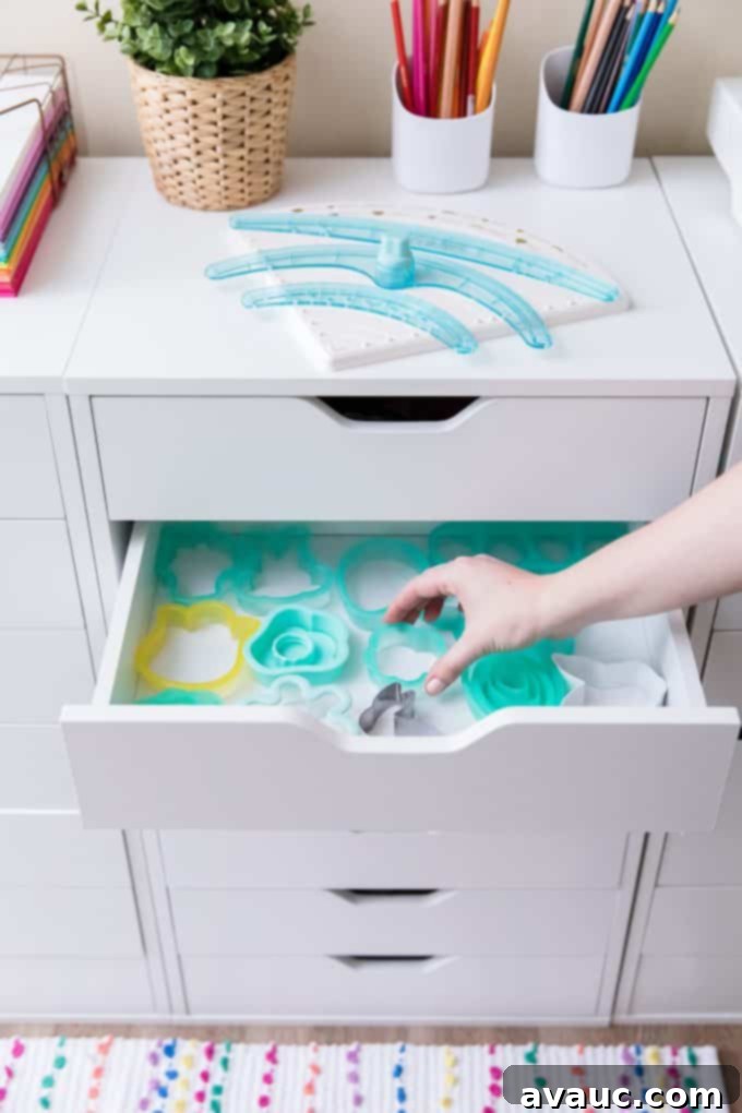A drawer neatly organized with cookie cutters, sorted by theme.