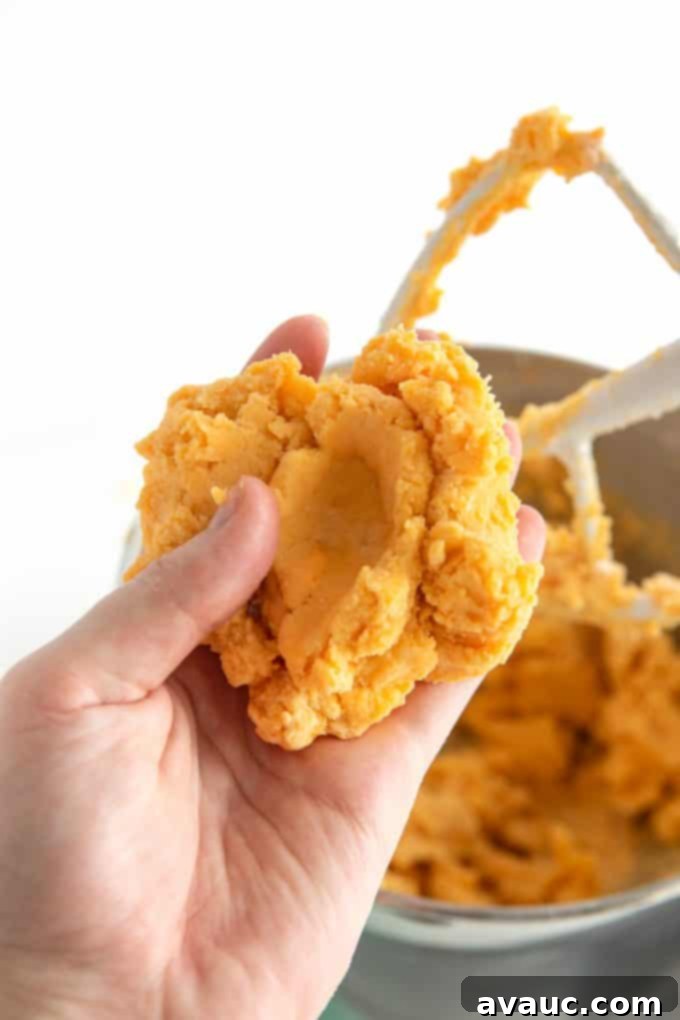 Hand holding cheese dough for homemade cheese crackers