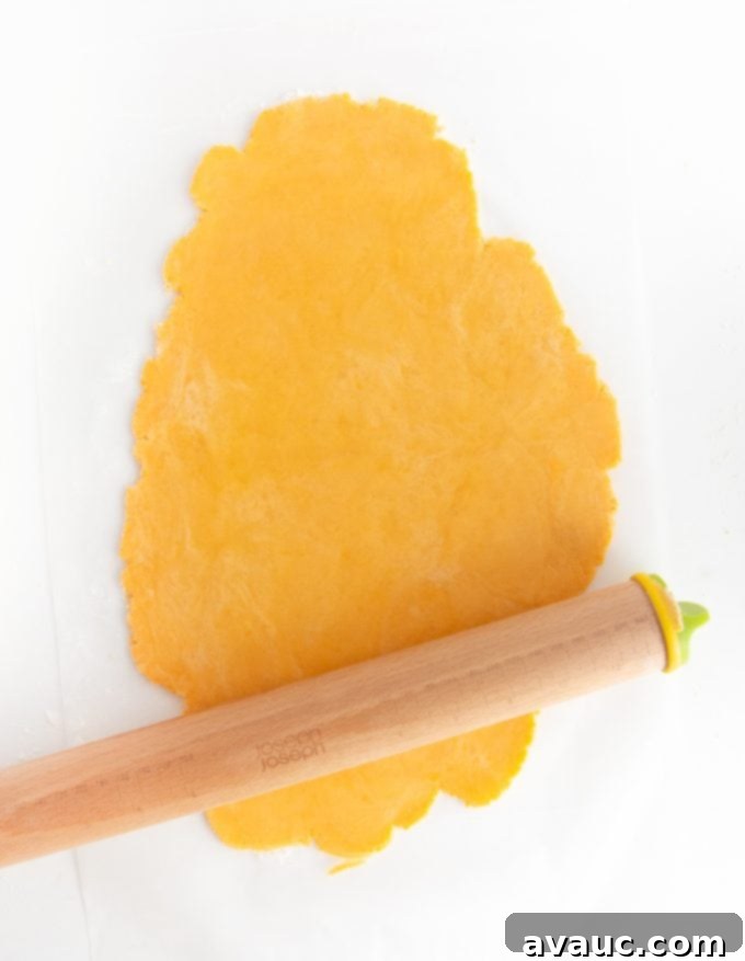 Rolling out homemade cheese cracker dough with rolling pin