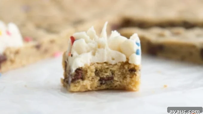 Stack of homemade cookie cake slices with frosting and sprinkles