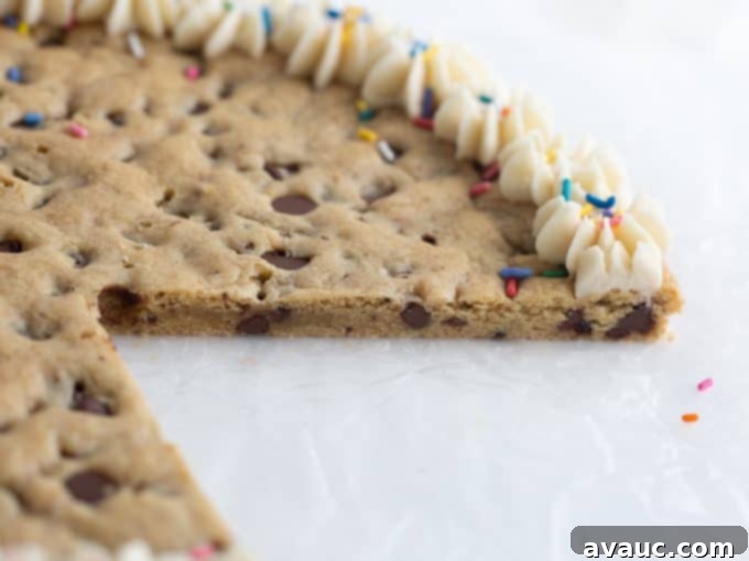Homemade cookie cake with a slice removed, showing its chewy interior