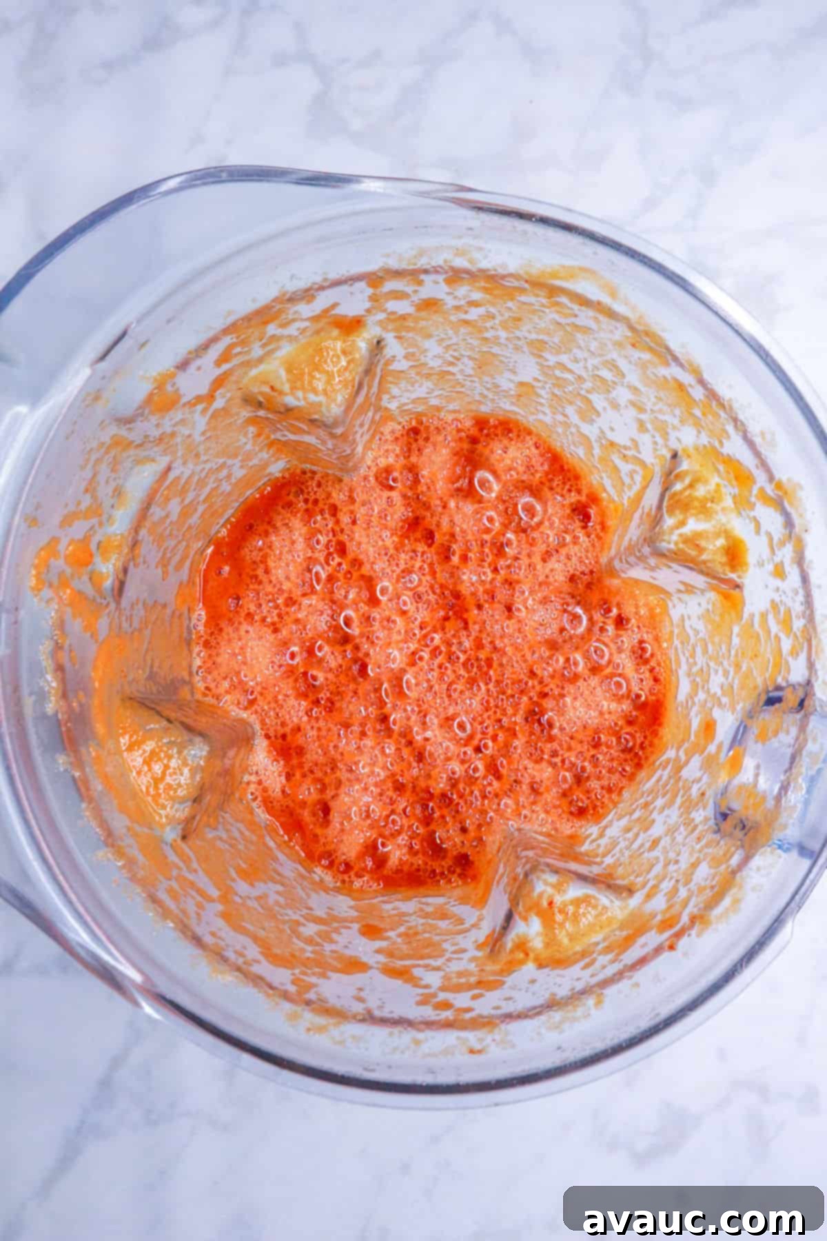 Chipotle tomato sauce ingredients being blended in a blender or food processor, creating a smooth, rich mixture.