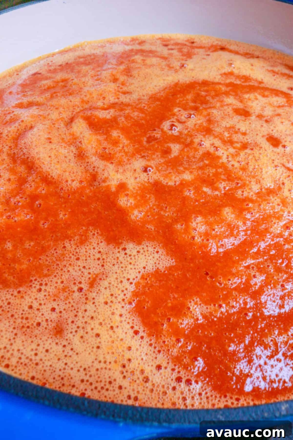 Sautéing the blended chipotle tomato sauce in a deep pot over medium heat, allowing flavors to meld.