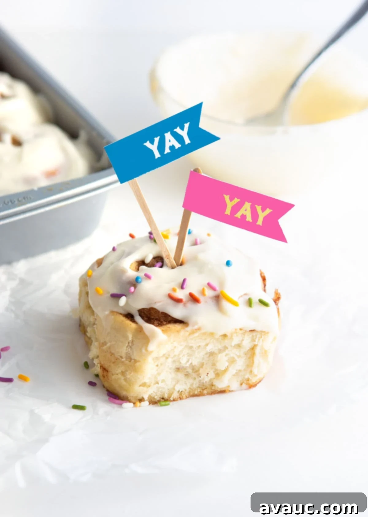 Cinnamon roll with rainbow sprinkles and fun 'yay' treat toppers for celebration