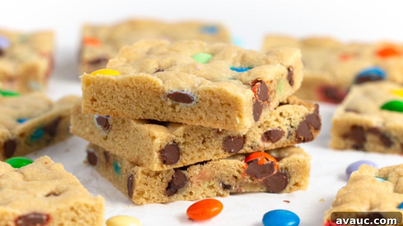 Colorful Chewy M and M Cookie Bars 8 A stack of perfectly cut, chewy M&M cookie bar squares on a white surface, showcasing their vibrant colors and soft texture.