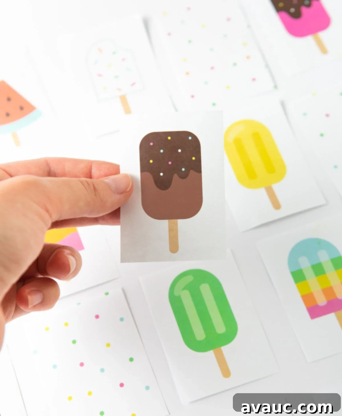 Ice Pop Memory Fun 7 A hand holding a chocolate popsicle printable memory card, showcasing its design.