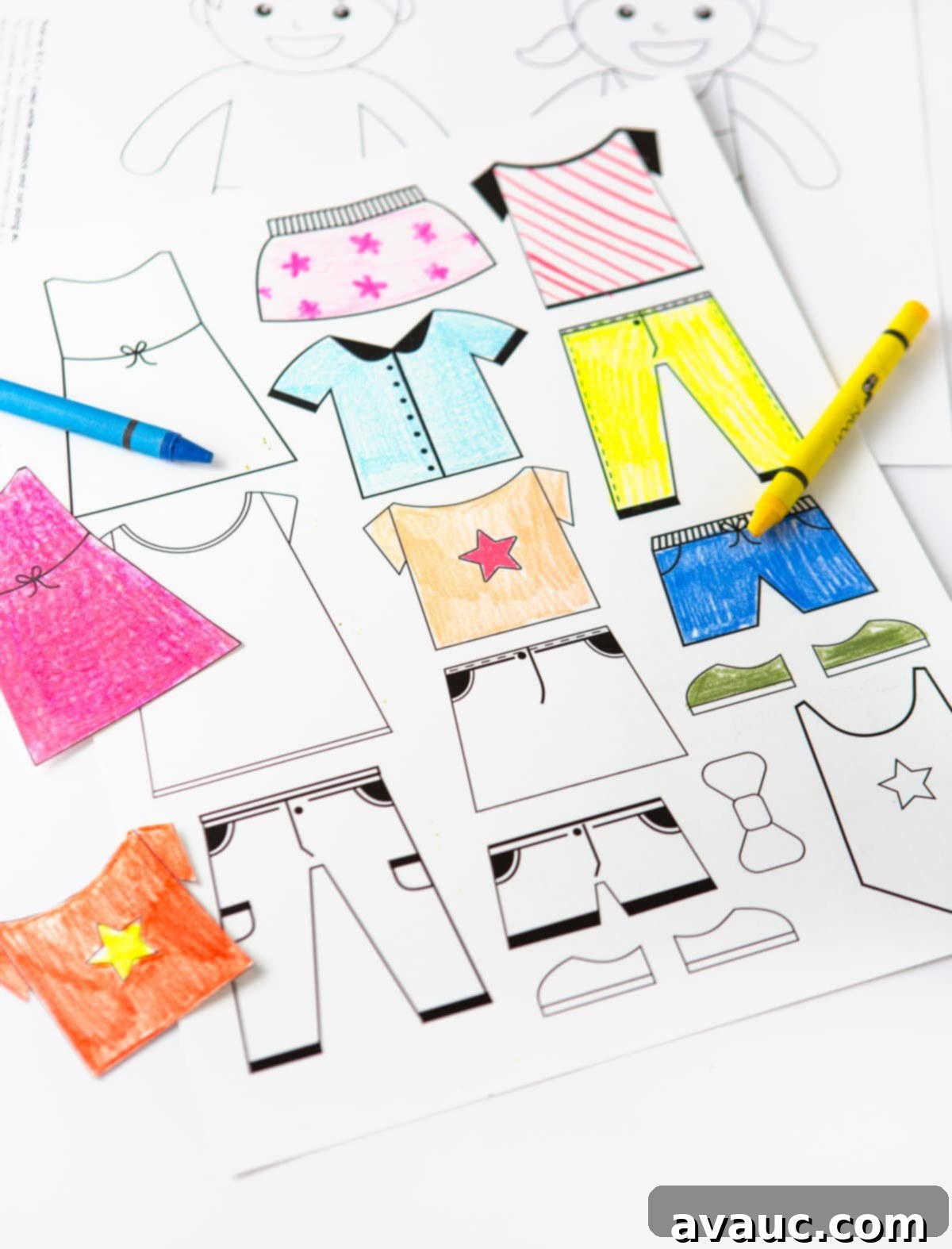 Collection of colorful, neatly cut out paper dolls and their diverse outfits laid on a flat surface