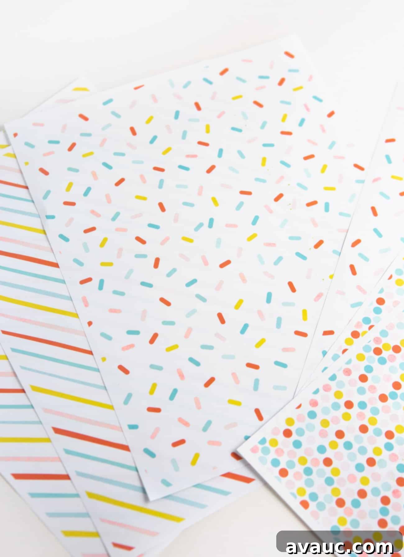 Hands cutting free printable birthday wrapping paper to size for a gift box.