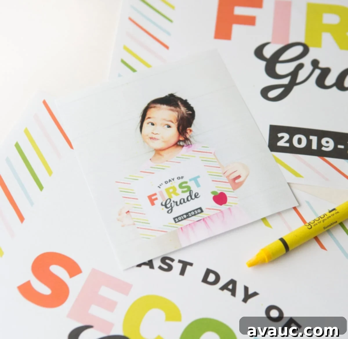 Child holding a colorful 'First Day of First Grade' sign, smiling for the camera
