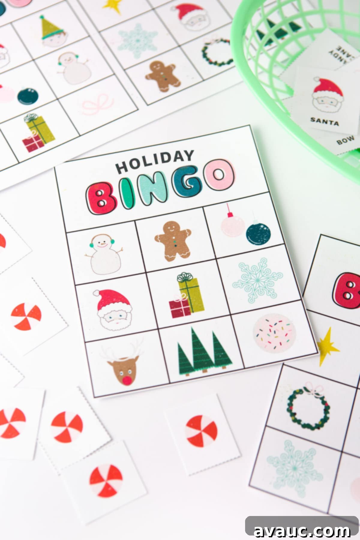 A person's hands holding two Christmas bingo cards with festive icons like Santa, reindeer, and gingerbread man.