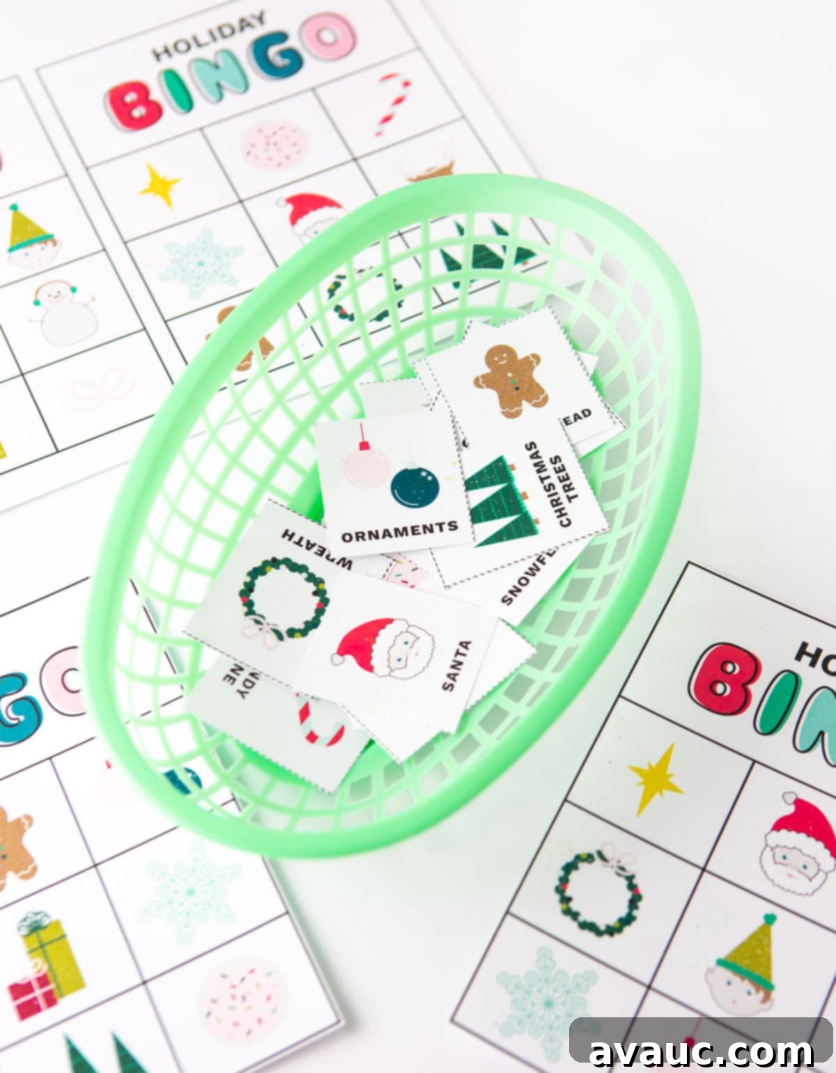 Close-up of hands cutting out Christmas bingo calling cards with scissors.