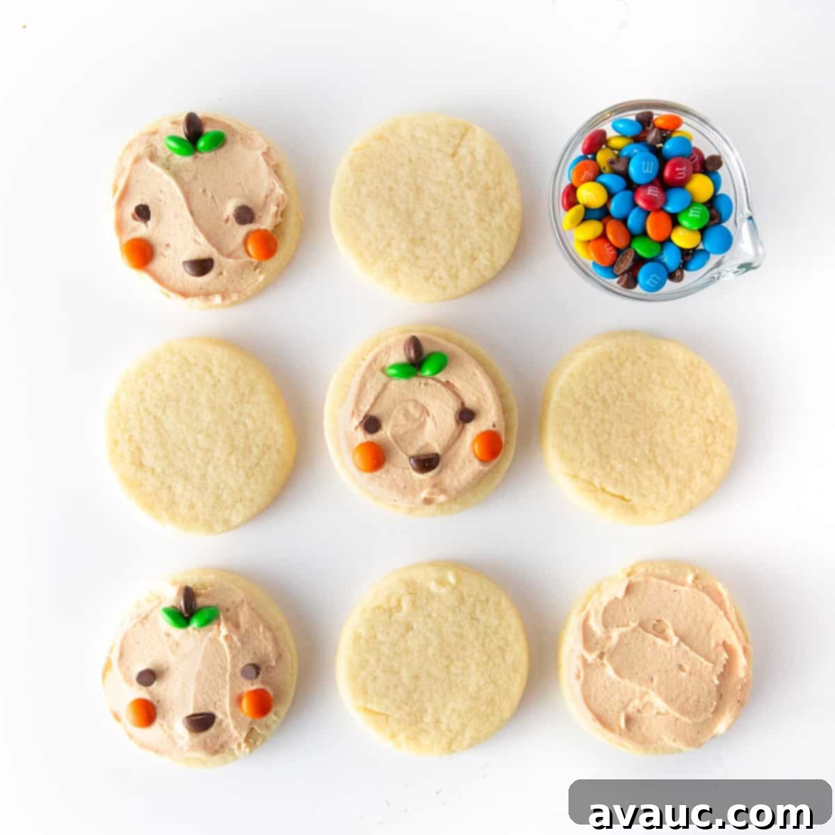 Spooktacularly Simple Pumpkin Cookies 3 Close-up of easy pumpkin Halloween cookies decorated with mini M&M's for eyes, cheeks, and mouth