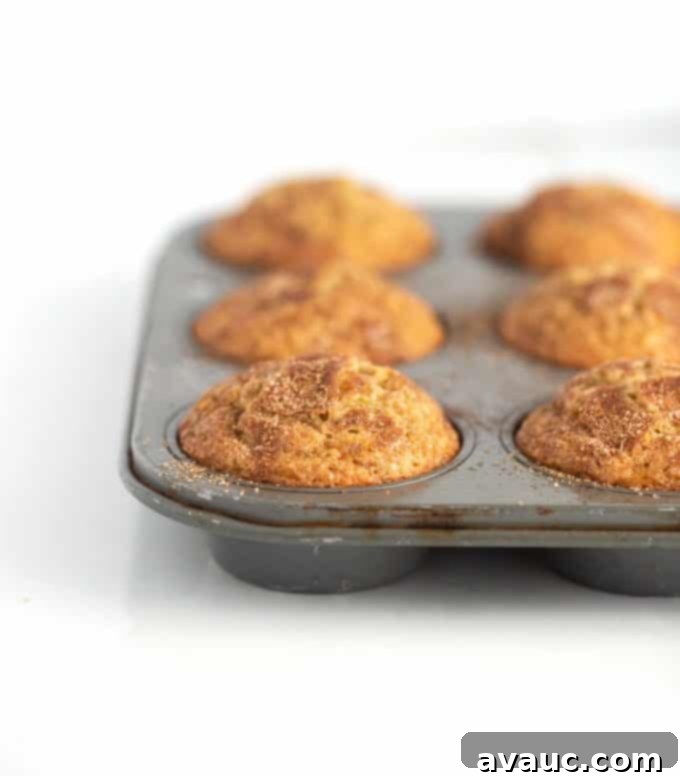 Melt-in-Your-Mouth Banana Bread Perfection 13 Metal muffin tin with banana muffins, showing a delicious golden-brown crust.