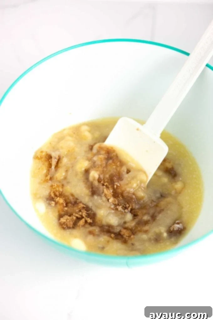 Melt-in-Your-Mouth Banana Bread Perfection 7 Stirring banana bread batter with a spatula in a large mixing bowl.
