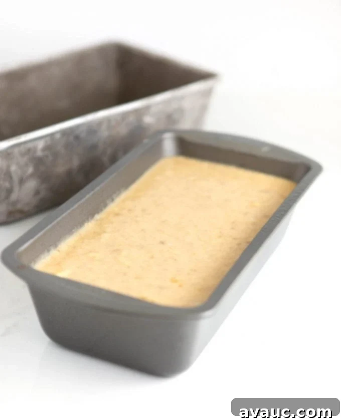 Melt-in-Your-Mouth Banana Bread Perfection 9 Metal loaf pan filled two-thirds full with smooth banana bread batter.
