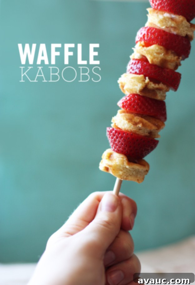 Freshly made waffle kabobs with strawberries and syrup, ready to be enjoyed.