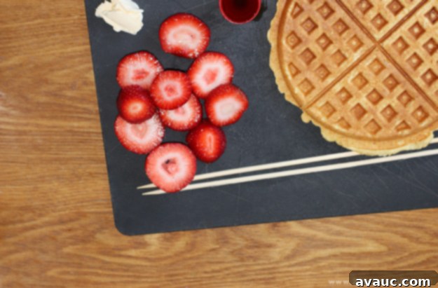 Ingredients laid out for waffle kabobs: waffles, strawberries, syrup, butter, and skewers.