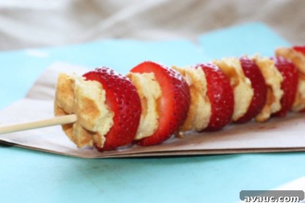 A completed waffle kabob held up, showcasing the beautiful arrangement of ingredients.