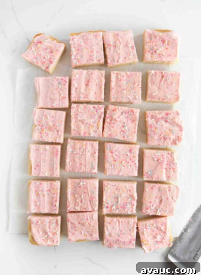 pan of cut sugar cookie bars with pink frosting and sprinkles, showing even squares