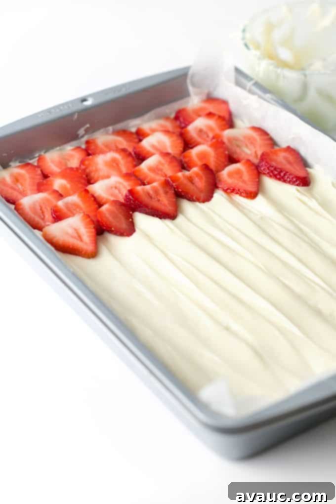 Pan of strawberry fruit pizza with cream cheese frosting and fresh berries