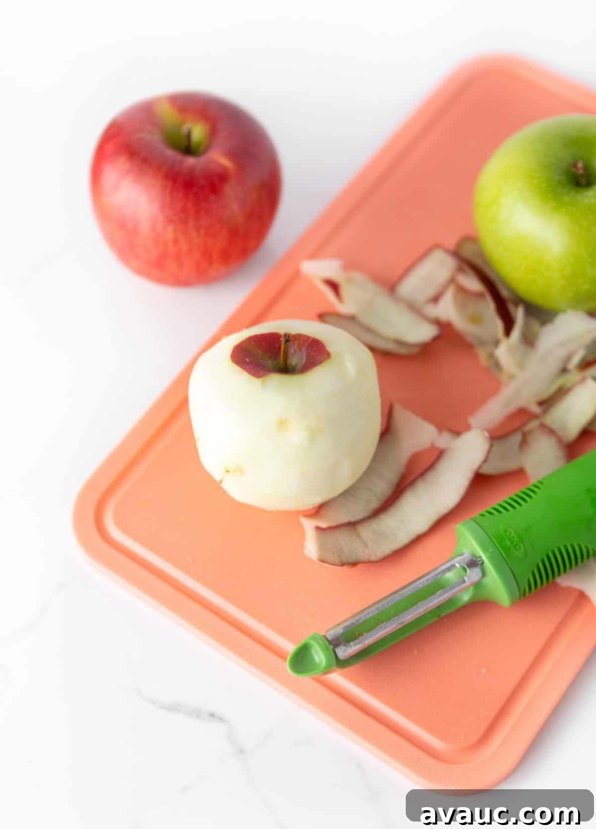 Pink cutting board peeling red and green apples