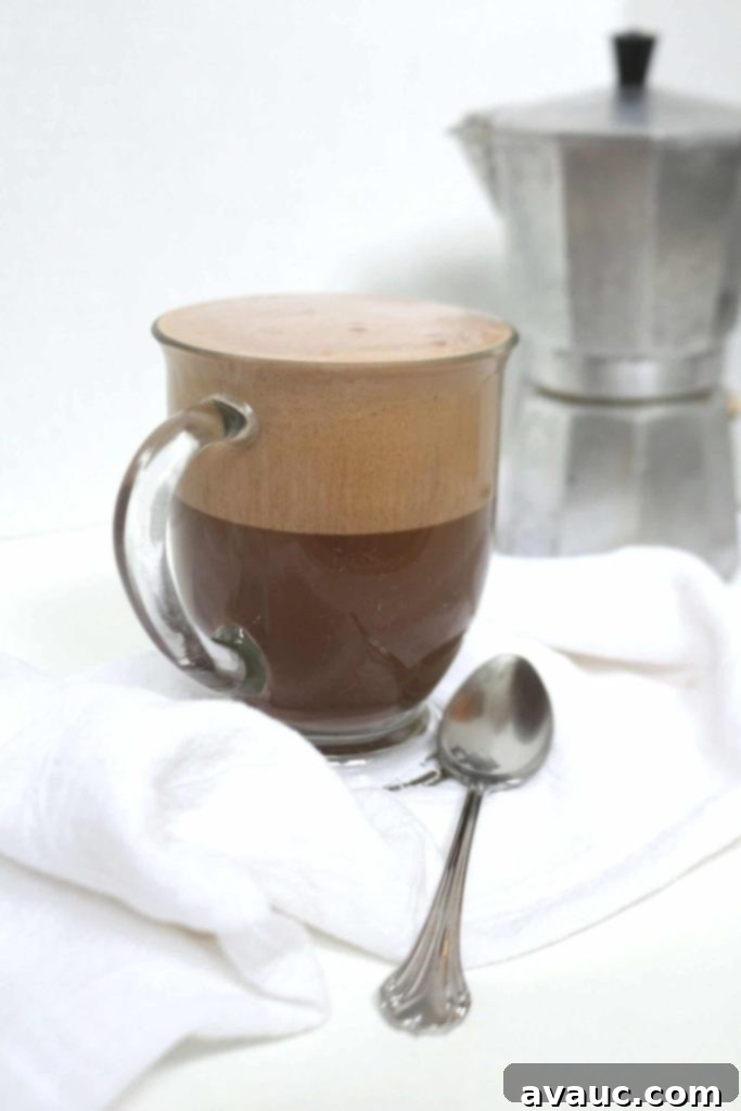 Cocoa Espresso Bliss 2 Mocha latte in a clear mug with a moka pot in the background, a perfect homemade dairy-free mocha