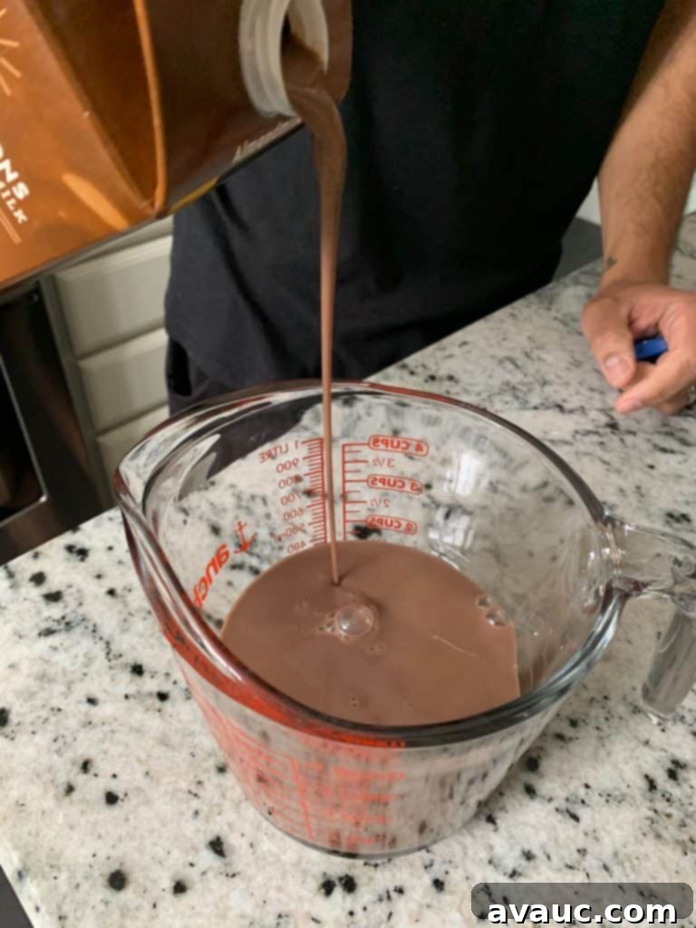 Cocoa Espresso Bliss 5 Pouring dairy-free almond milk into a glass measuring cup for frothing