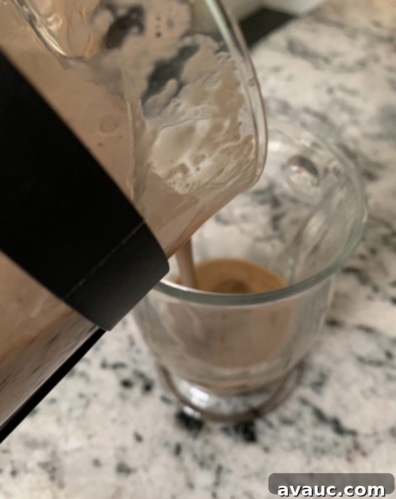 Cocoa Espresso Bliss 8 Pouring frothy dairy-free chocolate milk from a French press into a mug with coffee